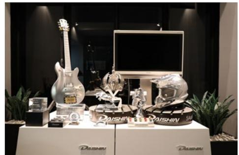 Display space for Daishin Seiki Co., Ltd. products, including a guitar and a helmet.