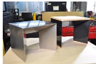 Two modern office desks, one silver and one wood-grain, in an office setting.