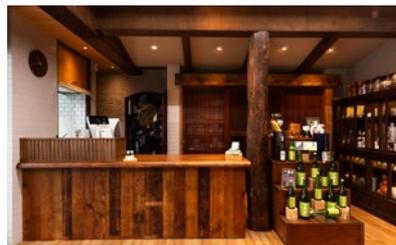 Interior design example of a shop or cafe using old wood for the counter and shelving.