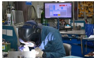 作業員がTEDソフトのモニターを見ながら溶接作業を行っている様子